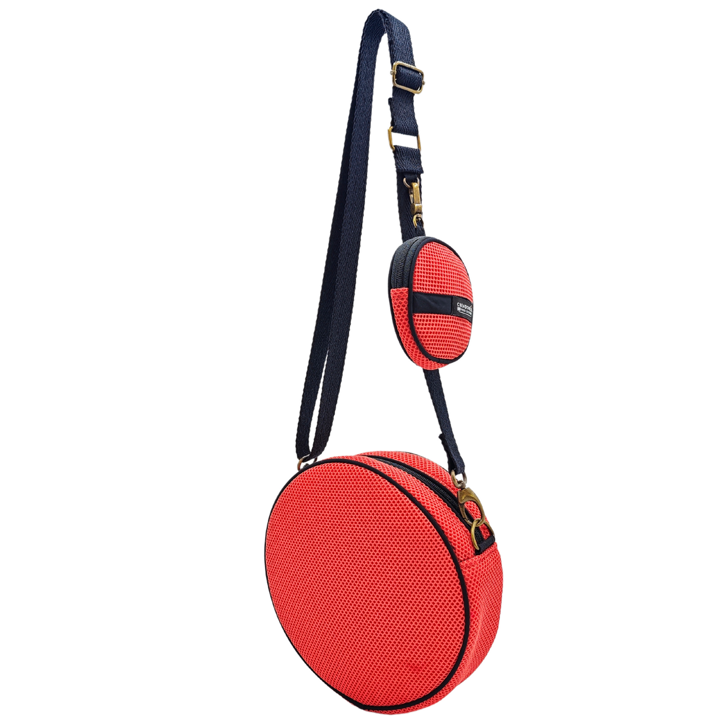 Compra nuestros bolsos circulares con monedero salmón-gris, hechos a mano con tejido 3D y material reciclado, elaborado artesanalmente por las mujeres del Programa Social de Creadoness.