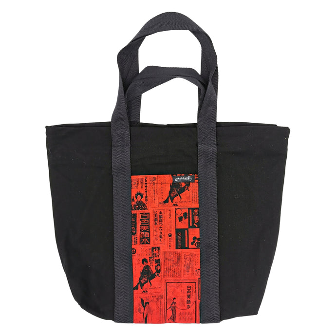 Maxi Bag hecha de algodón de color negra con un bolsillo exterior fondo rojo y con letras y figuras japonesas color negro. Posee cuatro asas de algodón. Su medida es de 46 cm de alto