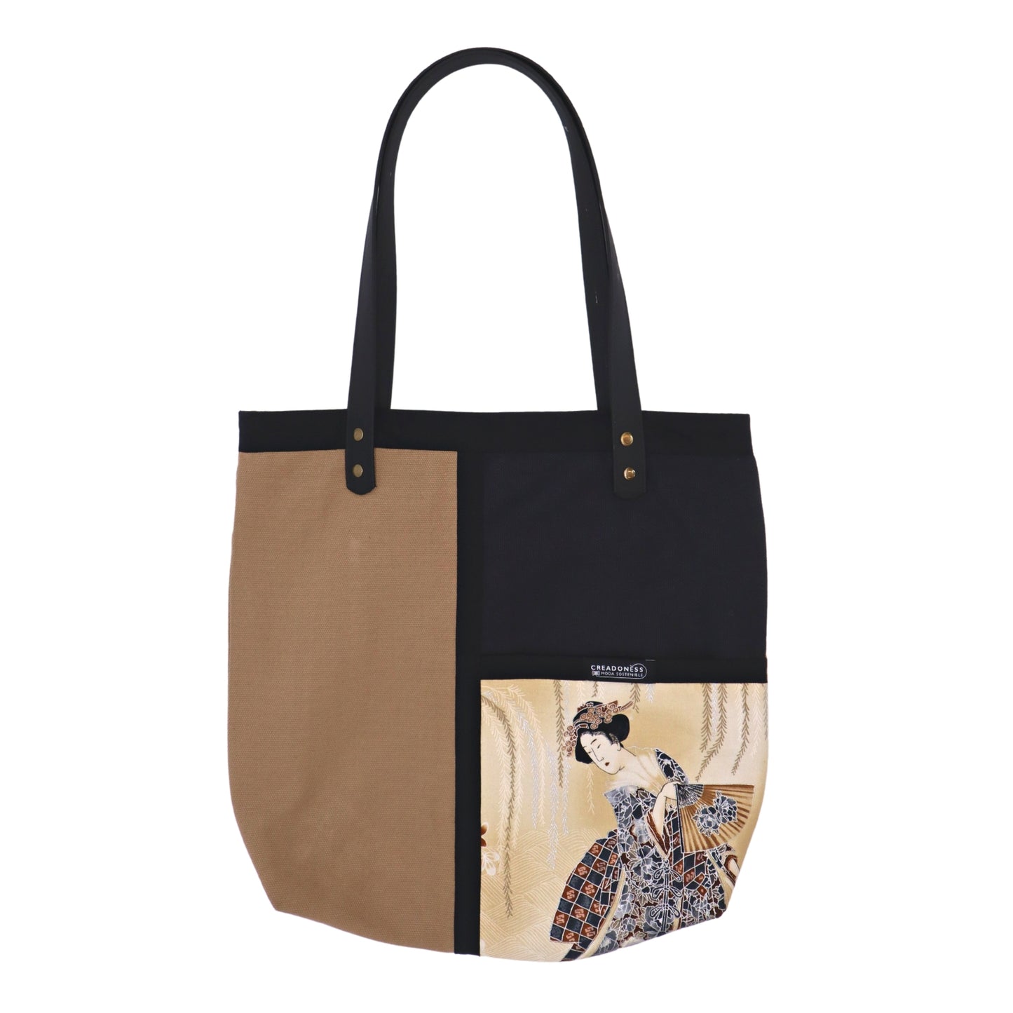 Tote Bag hecha de algodón de color beige. Tiene una estampa que cubre el lado derecho con un diseño japonés que muestra a una geisha bajo una lluvia de pétalos de flores. Posee dos asas de cuerina negra de 70 cm.