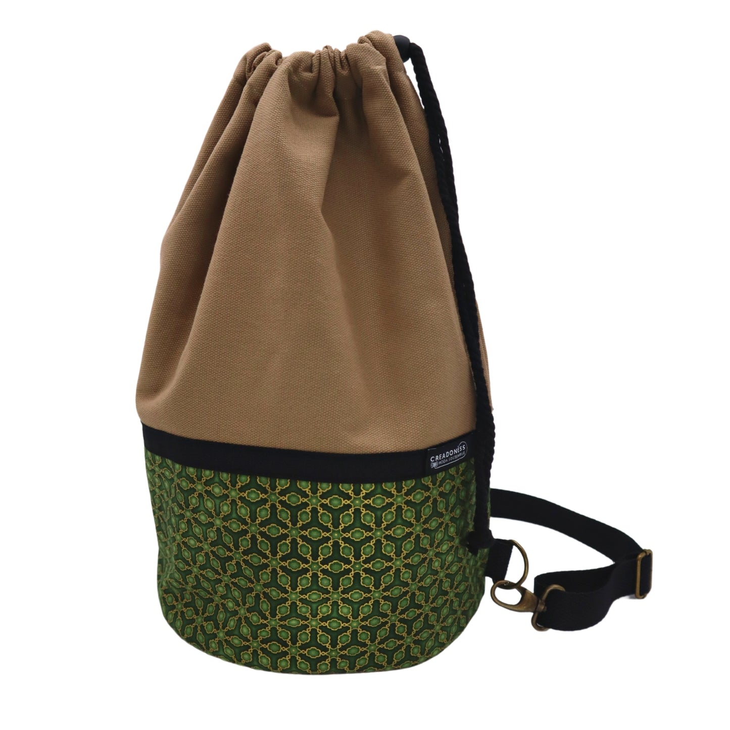 Mochila Petate de base circular de 24 cm de diámetro hecha de algodón. Su medida es de 38 cm de alto y 37 cm de ancho. Posee un asa bandolera para cruzar. En el interior tiene un bolsillo de 26 cm y un bolsillo oculto de 15 cm de profundidad.
