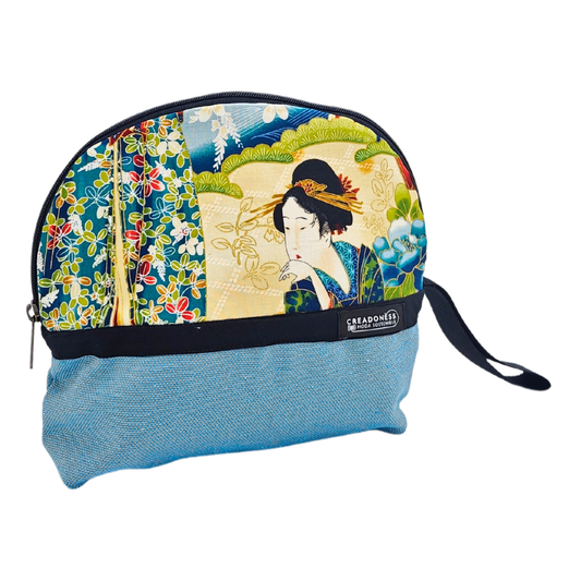 Descubre nuestro Neceser Grande Geisha, está hecho a mano con suave tela de algodón azul, elaborado artesanalmente por las mujeres del Programa Social de Creadoness.