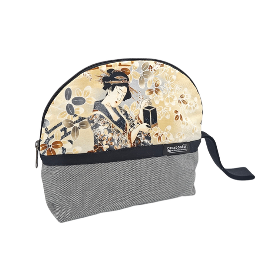 Descubre nuestro Neceser Grande Geisha, está hecho a mano con suave tela de algodón gris, elaborado artesanalmente por las mujeres del Programa Social de Creadoness.