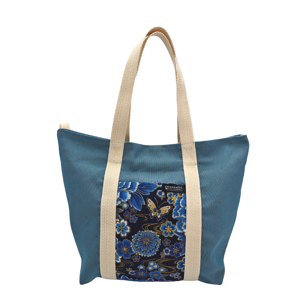 Descubre la Tote Bag Momo Aoi está hecha a mano con suave tela de algodón azul, elaboradas artesanalmente por las mujeres del Programa Social de Creadoness.