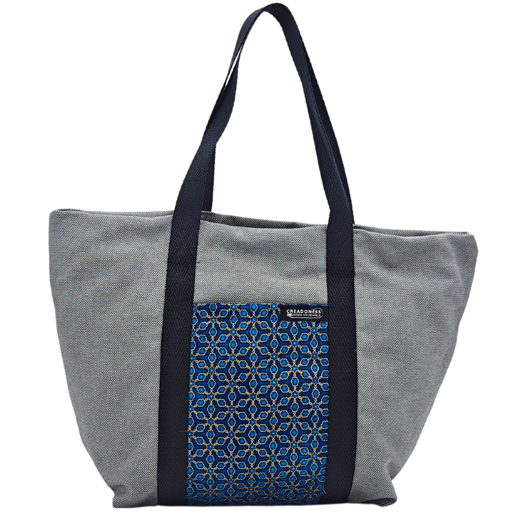 Descubre la Tote Bag Tsubaki está hecha a mano con suave tela de algodón gris, elaboradas artesanalmente por las mujeres del Programa Social de Creadoness.