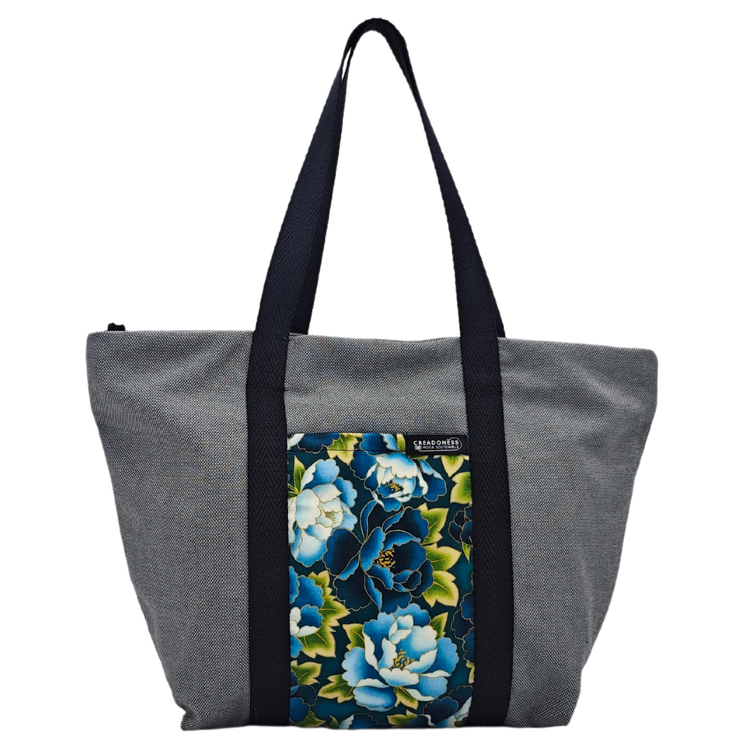 Descubre la Tote Bag Tsubaki está hecha a mano con suave tela de algodón gris, elaboradas artesanalmente por las mujeres del Programa Social de Creadoness.