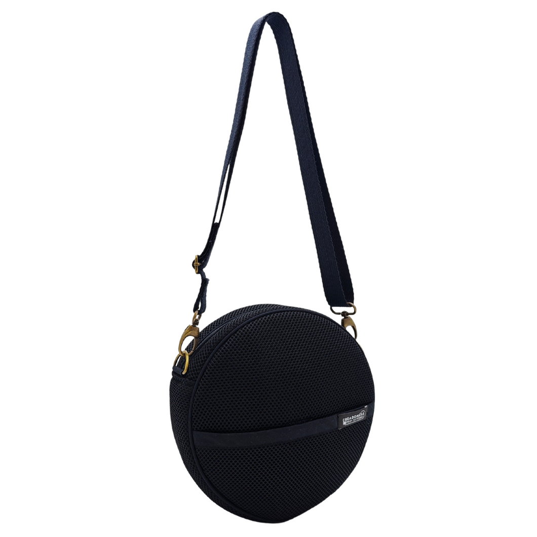 Compra nuestro bolso circular negro, hecho a mano con tejido 3D y material reciclado, elaborado artesanalmente por las mujeres del Programa Social de Creadoness.