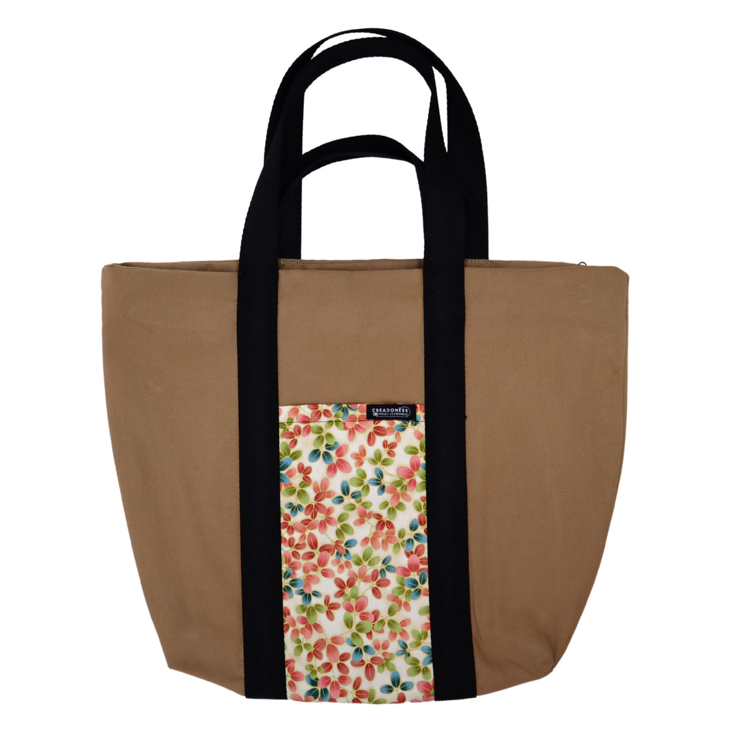Maxi Bag hecha de algodón de color beige con un bolsillo exterior con un estampado de flores de cerezo. Posee cuatro asas de algodón. Su medida es de 46 cm de alto.