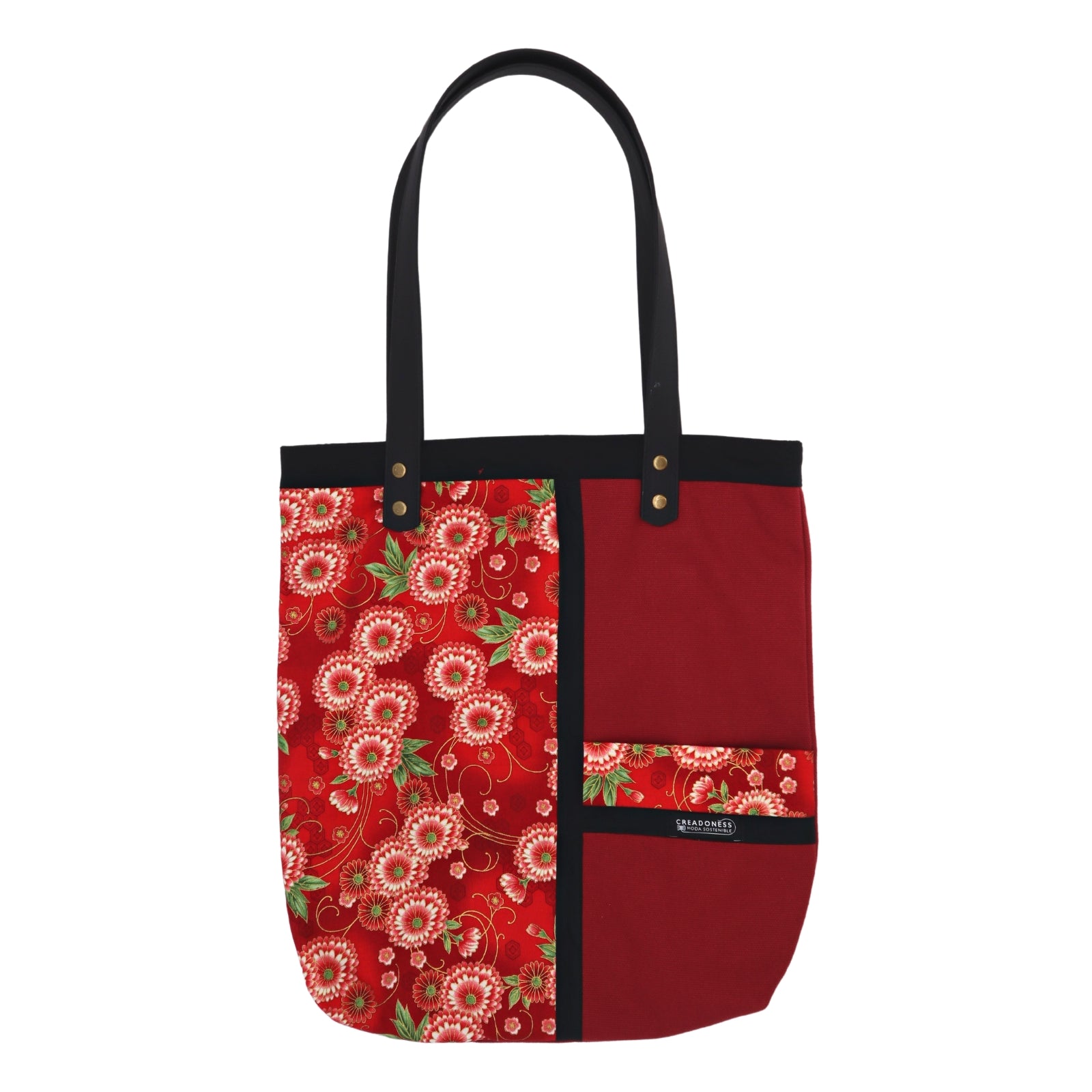 Tote Bag hecha de algodón de color granate. Tiene una estampa que cubre el lado derecho con un diseño de flores granate y blanco. Posee dos asas de cuerina negra de 70 cm.         