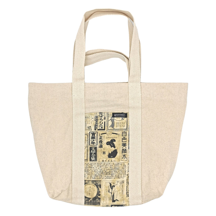 Maxi Bag hecha de algodón de color blanca con un bolsillo exterior con estampado color amarillo y diseño japonés donde se muestran distintas letras y frases japonesas. Su medida es de 46 cm de alto
