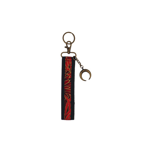 Llavero de algodón de color negro con estampado de flores rojas. Su medida es de 14 cm y por su diseño permite colocarlo en la muñeca.
