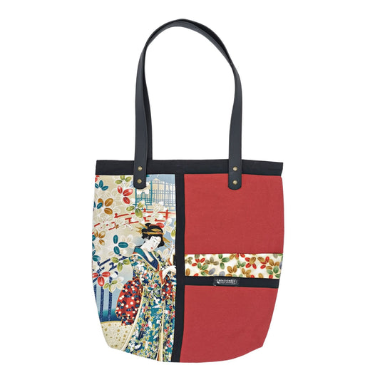 Tote Bag hecha de algodón de color Granate. Tiene una estampa que cubre el lado derecho con un diseño japones donde se meustra una geisha bajo una lluvia de petalos de flores. Del lado contrario tiene estampa pequeña horizontal con el mismo diseño que la estampa más grande. Posee dos asas de cuerina negra de 70 cm.