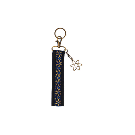 Llavero de algodón de color negro con estampado geométrico azul. Su medida es de 14 cm y por su diseño permite colocarlo en la muñeca.