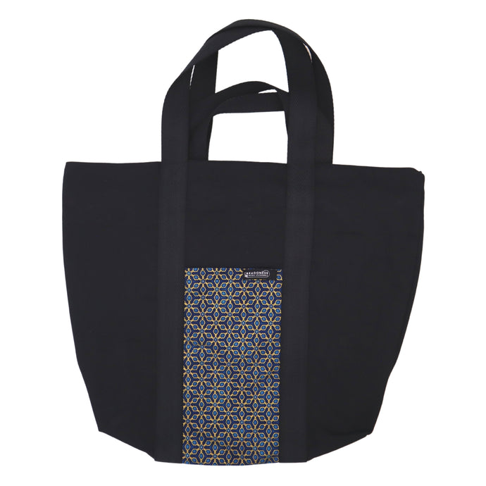 Maxi Bag hecha de algodón de color blanca con un bolsillo exterior con estampado azul y diseño geométrico. Su medida es de 46 cm de alto