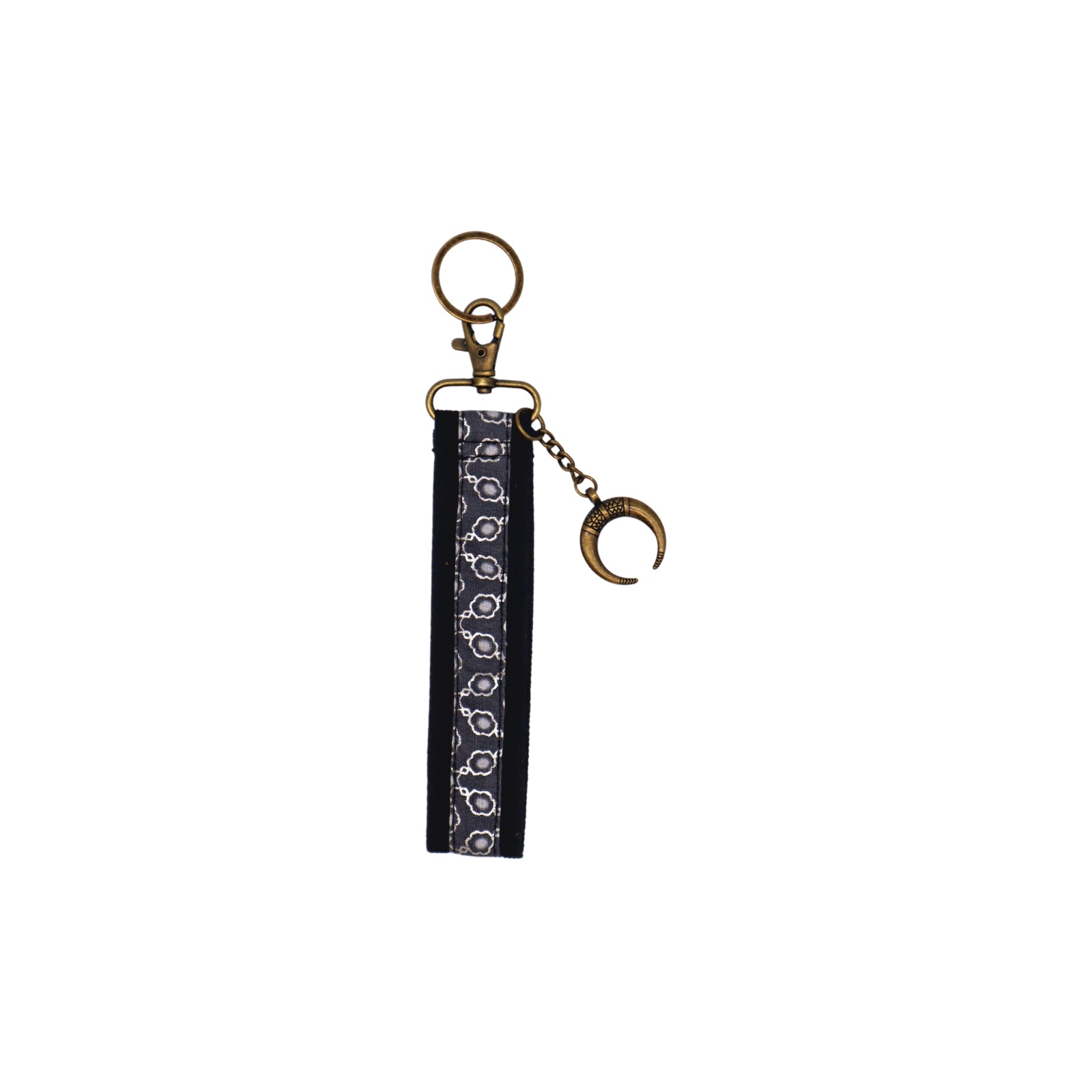 Llavero de algodón de color negro con estampado geométrico gris. Su medida es de 14 cm y por su diseño permite colocarlo en la muñeca.